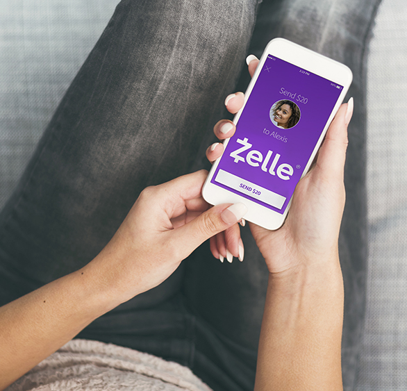 Woman sending money to friends and family with Zelle on her mobile phone, using the MidWestOne banking app.